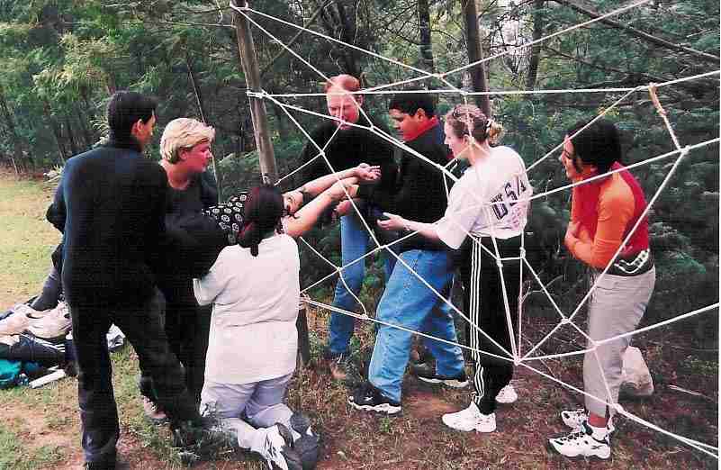 A team going through a spider web obstacle